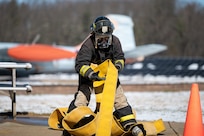 A photo of Emily Buffum, a student at the Stafford Technical Center, pulling in a line of hose during a SkillsUSA competition at the Vermont Air National Guard Base in South Burlington, VT, April 8, 2026.