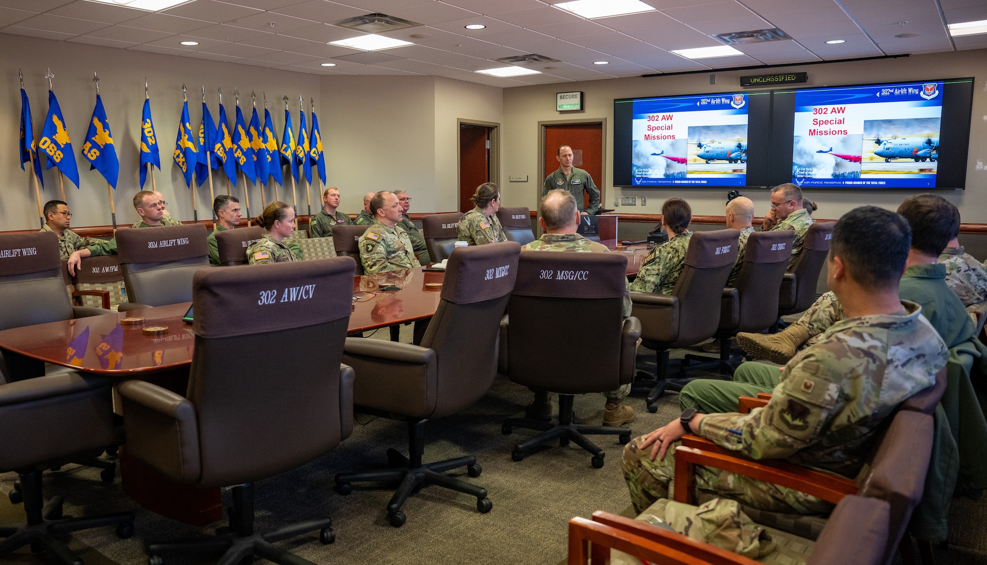 U.S. service members sit in a conference room