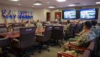 U.S. service members sit in a conference room