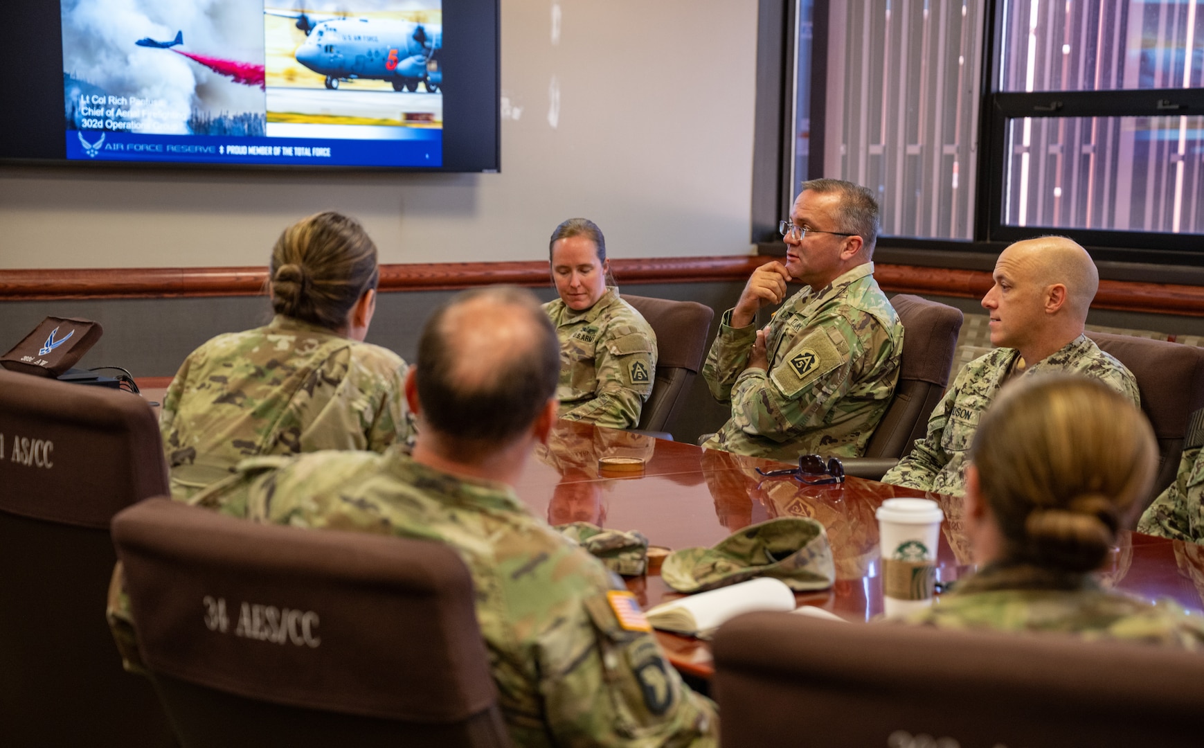 U.S. service members sit in a conference room