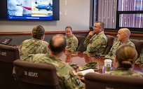 U.S. service members sit in a conference room