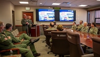 U.S. service members sit in a conference room