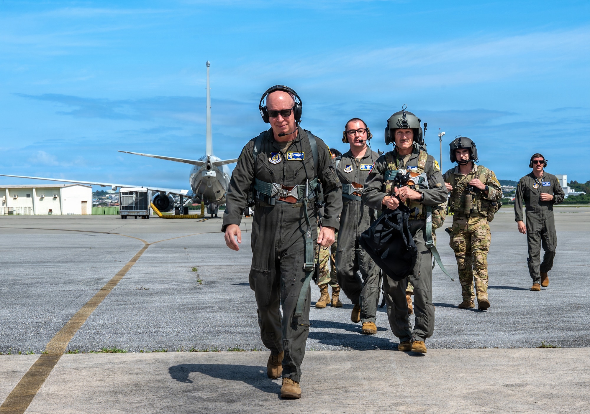 A group a people walk towards the camera in flight gear