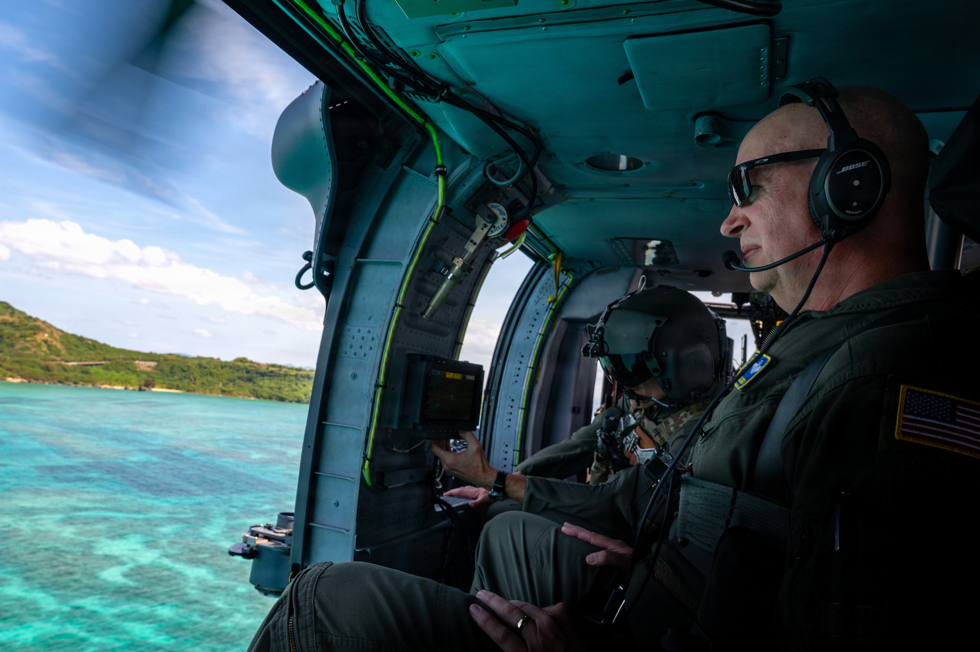 People fly in a helicopter and look at the ocean below