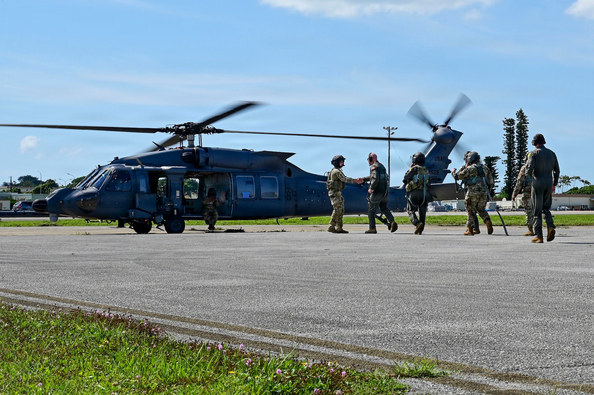 a group of people walk to a helicopter