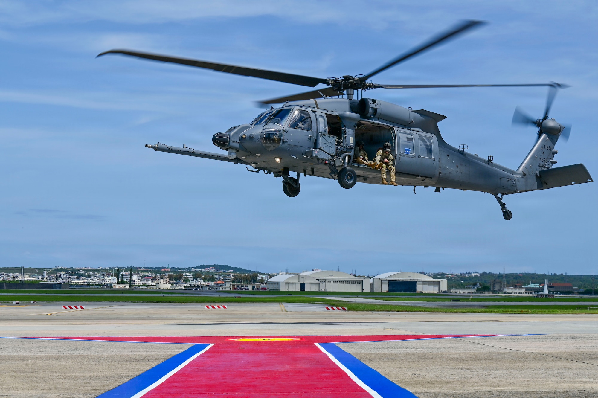 A helicopter hovers over a flight line