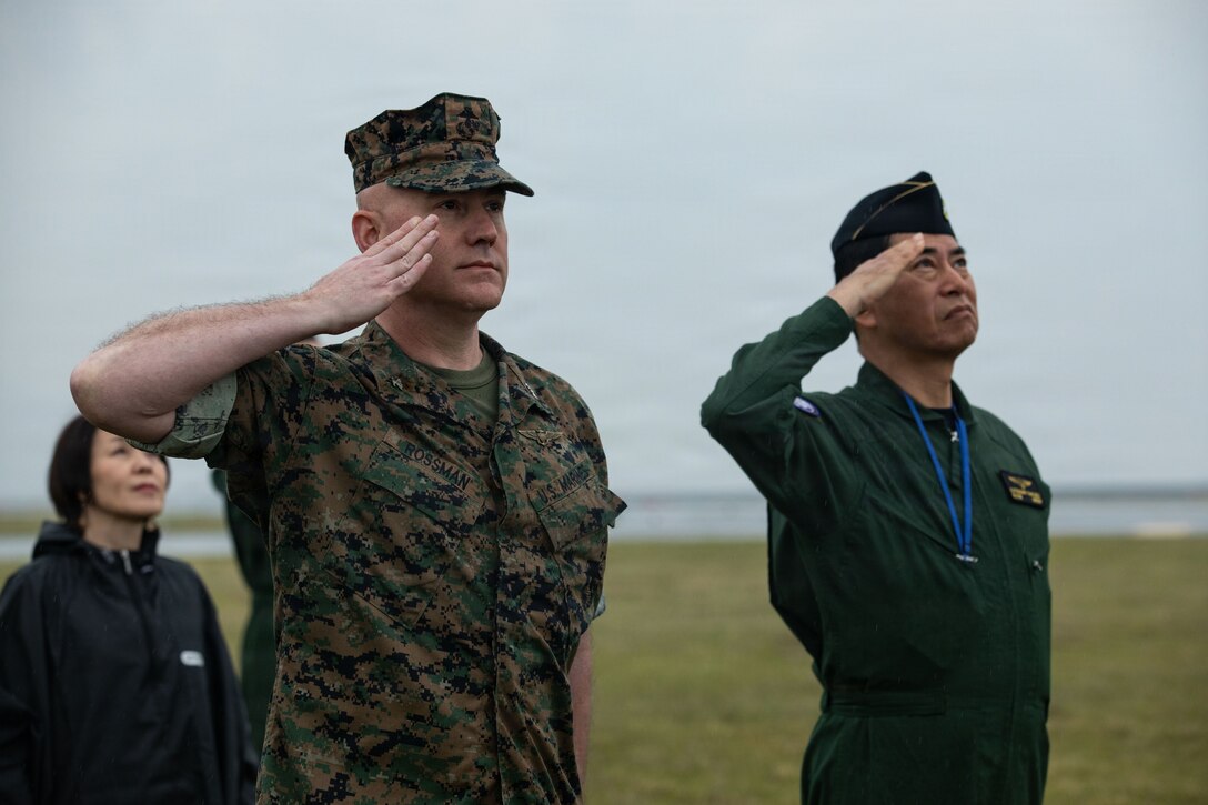 U.S. Marine Corps Col. Kenneth Rossman, left, the commanding officer of Marine Corps Air Station Iwakuni, and a native of Pittsburgh, Pennsylvania, and Japan Maritime Self-Defense Force Rear Admiral Katsushi Okubo, the commander of Fleet Air Wing 31, Japan Maritime Self-Defense Force, salute for the U.S. and Japan national anthems during Friendship Day at MCAS Iwakuni, Japan, May 3, 2026. The JMSDF-MCAS Iwakuni Friendship Day is hosted annually to strengthen relationships with the host community and offer a cultural exchange that highlights the mutual support between the U.S. and Japan. (U.S. Marine Corps Photo by Cpl. Ella Cadby)