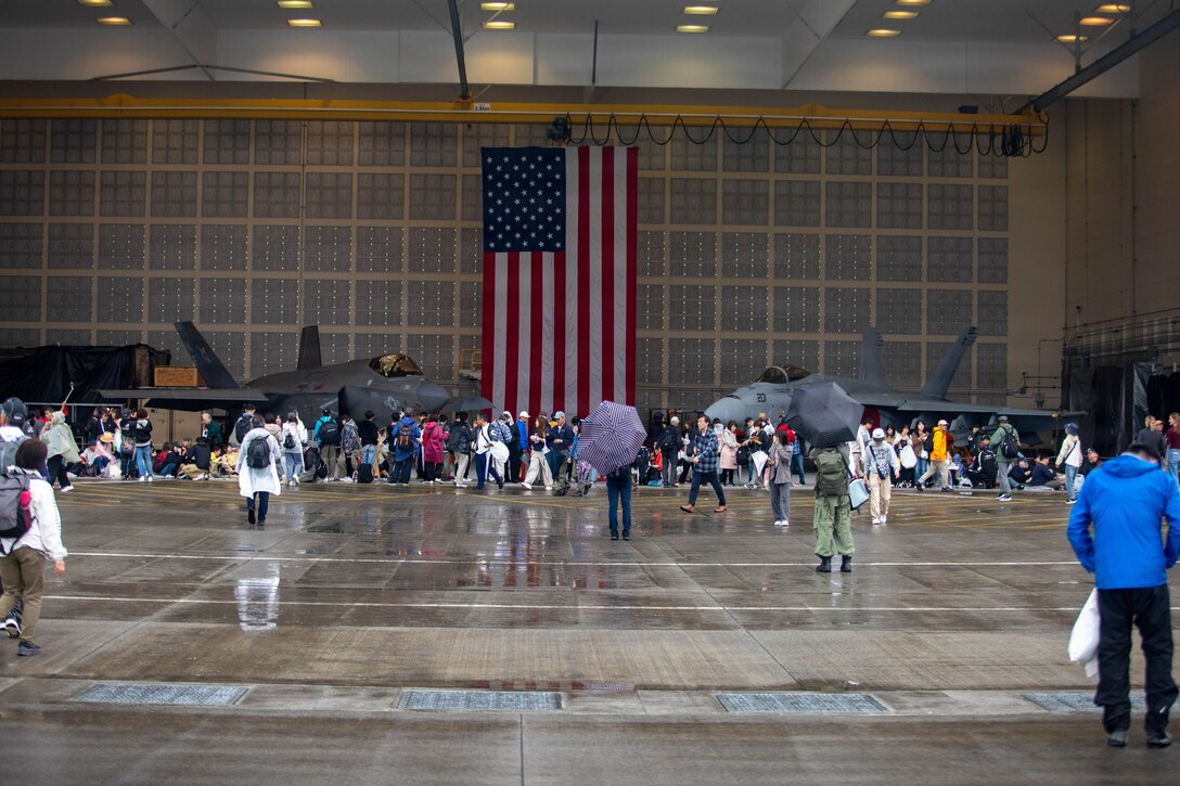 Guests observe a U.S. Navy F-35C Lightning II with Strike Fighter Squadron (VFA) 147, Carrier Air Wing 5, and a U.S. Navy F/A-18E Super Hornet with Strike Fighter Squadron (VFA) 27, Carrier Air Wing 5, during Friendship Day at Marine Corps Air Station Iwakuni, May 3, 2026. Since 1973, MCAS Iwakuni has held an air show designed to foster positive relationships and offer an exciting experience that displays the communal support between the U.S. and Japan. The air show encompassed various U.S. and Japanese static display aircraft, aerial performances, food and entertainment. (U.S. Marine Corps Photo by Lance Cpl. Rylan Adcock)
