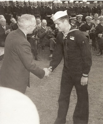 President Harry S. Truman congratulates Hospital Apprentice First Class Robert E. Bush after presenting him the Medal of Honor during a ceremony in 1945. Bush, a U.S. Navy hospital corpsman, was recognized for his actions while providing aid to wounded Marines under fire during the Battle of Okinawa. (U.S. Navy photo)