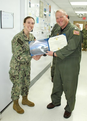 Lt. Natalie Grose, a Physician Assistant at Naval Medical Readiness and Training Command (NMRTC) Patuxent River, is awarded a Navy and Marine Corps Achievement Medal by Cmdr. Daniel Maine, Officer in Charge of Fleet Air Reconnaissance Squadron Four (VQ-4). Grose received the award for her exceptional leadership as the primary competent medical authority, leading a complete overhaul of the command’s Personnel Reliability Program (PRP). The PRP is a critical safeguard for the nation's strategic nuclear deterrence posture, and Grose's work ensured the VQ-4 "Shadows" had uncompromising medical support