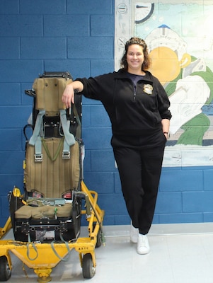 Lt. Cmdr. Hadley Sulpizio, an Aerospace Operational Physiologist, stands inside the Navy Aviation Survival Training Center (ASTC) Patuxent River as U.S. Naval Academy Midshipmen participate in an on-site training day. Representing the Research and Applied Sciences pillar of the Navy Medical Service Corps, Sulpizio directs CNO-mandated, high-risk survival and physiological training for over 2,500 joint warfighters annually, ensuring future naval officers and test aircrews are prepared to operate safely in extreme environments.