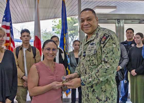 YOKOSUKA, Japan (April 15, 2026) — Capt. Torrin W. Velazquez, director of U.S. Naval Hospital (USNH) Yokosuka, presents his personal commanding officer’s coin to registered nurse Brittany Hernandez from U.S. Naval Hospital Okinawa during the High-Level Disinfection and Sterilization (HLD/SPD) workshop at USNH Yokosuka, April 15. Hernandez was recognized for her support coordinating virtual participation and helping expand specialized reprocessing education across the Indo-Pacific region. The four-day workshop brought together healthcare professionals from across multiple commands and countries to strengthen patient safety, interoperability and medical readiness. (U.S. Navy photo by Daniel Taylor/USNMRTC Yokosuka Public Affairs)
