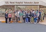 YOKOSUKA, Japan (April 15, 2026) — Capt. Torrin W. Velazquez, director of U.S. Naval Hospital (USNH) Yokosuka, poses for a group photo with instructors, organizers and participants of the High-Level Disinfection and Sterilization (HLD/SPD) workshop outside USNH Yokosuka, April 15. Hosted for the first time in mainland Japan, the workshop brought together nearly 100 participants from across the Indo-Pacific and beyond to strengthen standardized sterilization and high-level disinfection practices supporting patient safety, mission success and force health protection. (U.S. Navy photo by Daniel Taylor/USNMRTC Yokosuka Public Affairs)