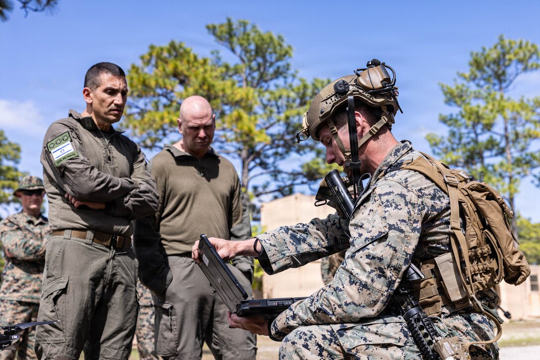 U.S. Marine Corps Sgt. Cooper Becker, a squad leader with 2nd Combat Engineer Battalion, 2nd Marine Division, conducts a Skydio X2D small unmanned aircraft system showcase to Israeli Defense Force soldiers Lt. Col. Ofir Samish, left and Col. Eli David, during a Marine Corps Combat Readiness Evaluation on Marine Corps Base Camp Lejeune, North Carolina, April 27, 2026. The IDF engaged with 2nd CEB to exchange engineer capabilities and small unmanned aerial systems to better understand the similarities and differences between both armed forces. Marines participated in a MCCRE to be assessed on unit combat readiness and ability to execute mission critical tasks in preparation for future operations and deployments. (U.S. Marine Corps photo by Cpl. Judith Ann Lazaro)