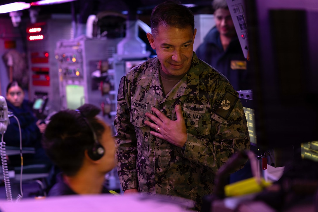 U.S. Navy Admiral Brad Cooper, commander of U.S. Central Command, speaks with a Sailor in the combat information center aboard America-class amphibious assault ship USS Tripoli (LHA 7). Cooper interacted with Sailors and Marines and toured various spaces aboard the amphibious assault ship. Tripoli is deployed to the U.S. 5th Fleet area of operations to support maritime security and stability in the Middle East. (U.S. Navy photo by Senior Chief Mass Communication Specialist Amanda Dunford)