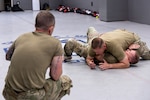 U.S. Air Force Master Sgt. Daniel K. Ayers, 145th Security Forces Squadron, or SFS, unit training manager, top, demonstrates the side-mount guard position on Master Sgt. Steven T. Johnson, 145th SFS instructor, bottom, at the Charlotte-Mecklenburg Police Department Training Academy, Charlotte, N.C., May 2, 2026.