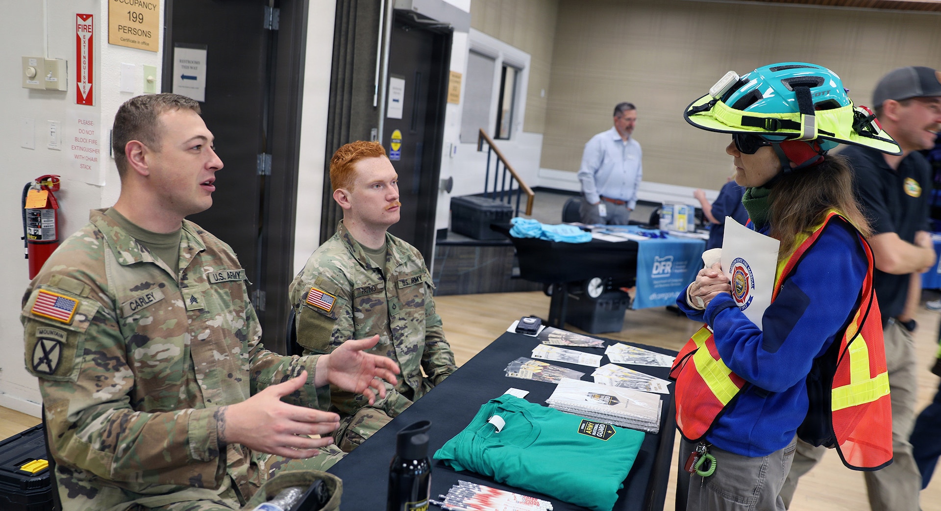 Sgt. Rocco Carley, an Oregon Army National Guard recruiter with 2-162 Infantry Battalion, and Pfc. Christian Patino, also an infantryman 2-162, speak with a community member during the Wildfire Readiness Fair in Corvallis, Oregon, on May 2, 2026.