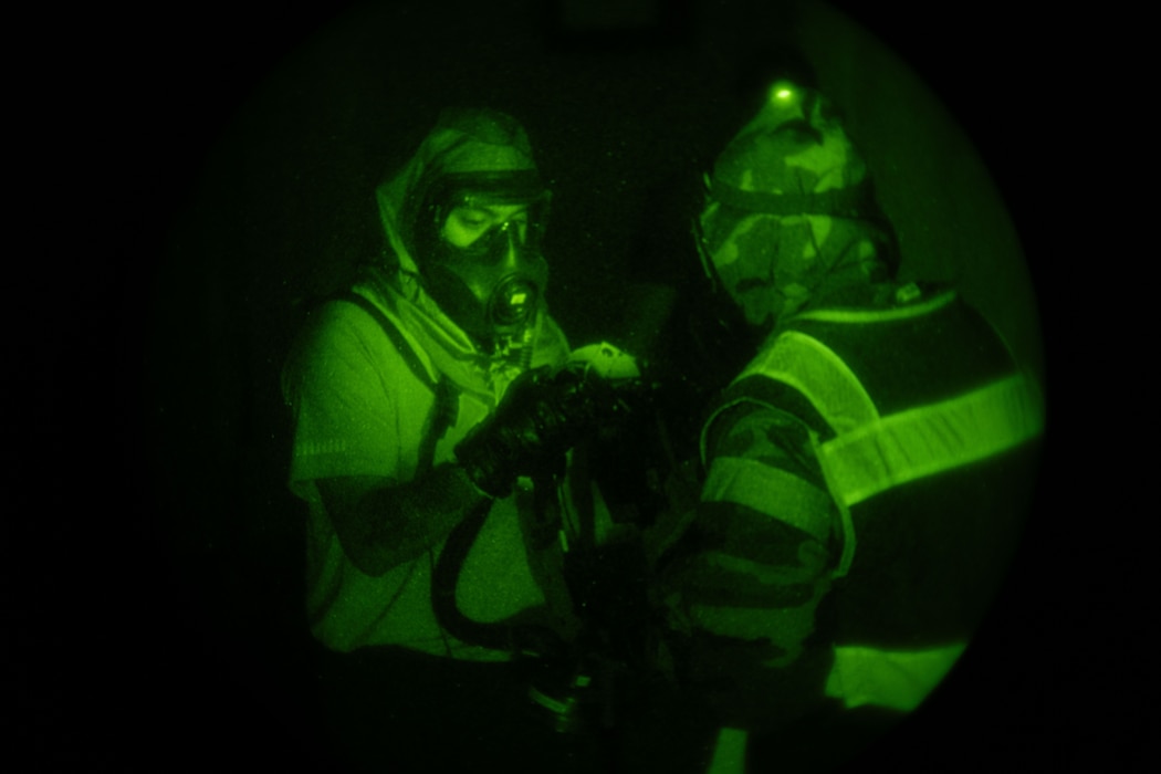 A team of people exam equipment in the dark.