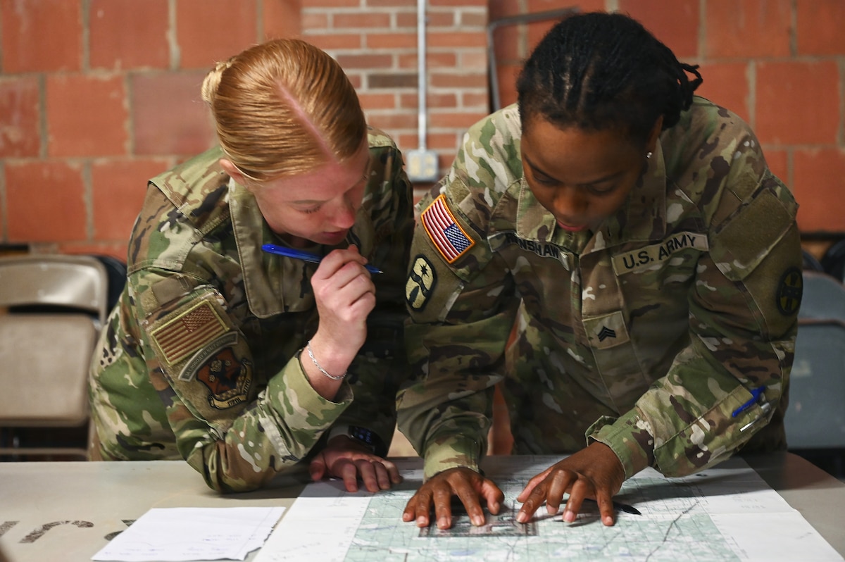Two religious affairs specialists determine an azimuth on a map during land navigation training