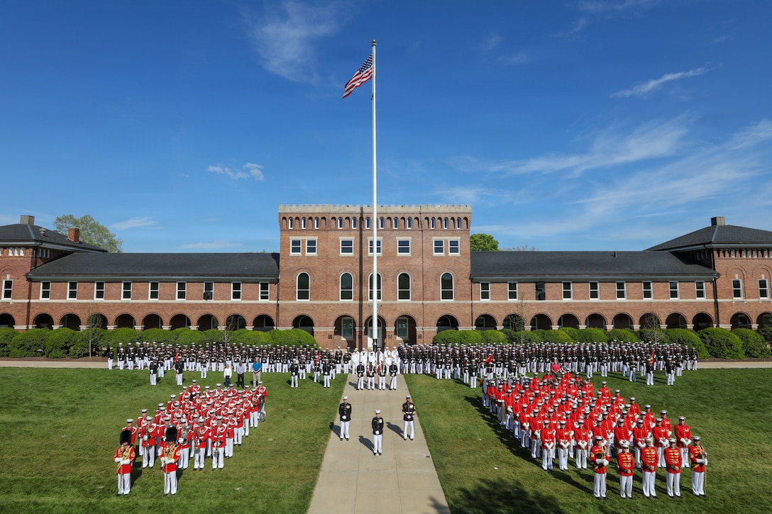 U.S. Marines, Sailors, and civilians at Marine Barracks Washington pose for a battalion photo on the parade deck in front of Building 8 at Marine Barracks Washington, D.C., on April 14, 2026. Every Marine, Sailor and civilian plays a key role in maintaining the high standards of ceremonial and military excellence at the "Oldest Post of the Corps". (U.S. Marine Corps photo by Cpl. Christopher Prelle)