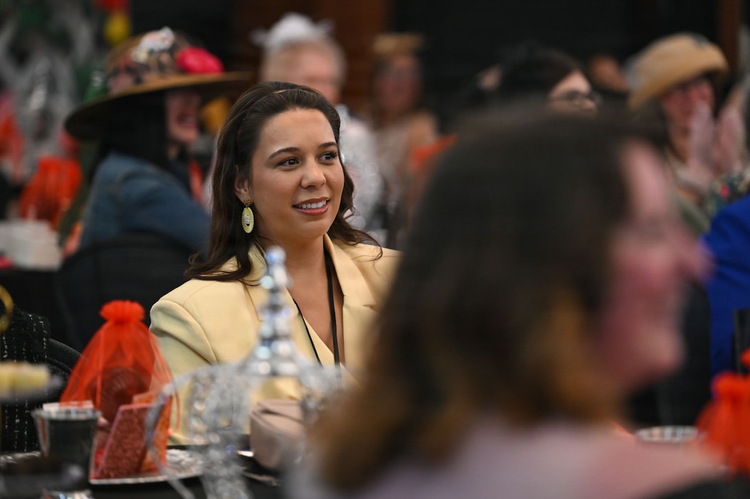 Meagan Childers, military spouse, receives information about the “Military Spouse Story Highlights” gallery during the military spouse appreciation event at Joint Base Andrews, Maryland, May 1, 2026.