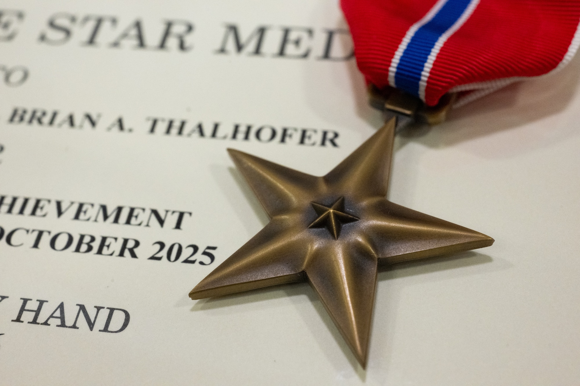 A Bronze Star medal and award citation belonging to U.S. Air Force Lt. Col. Brian Thalhofer, 436th Airlift Wing Safety chief, at Dover Air Force Base, Delaware, April 29, 2026. Thalhofer was one of four Dover AFB Airmen awarded the Bronze Star for their heroic actions while deployed to Al Udeid Air Base, Qatar. (U.S. Air Force photo by Mauricio Campino)