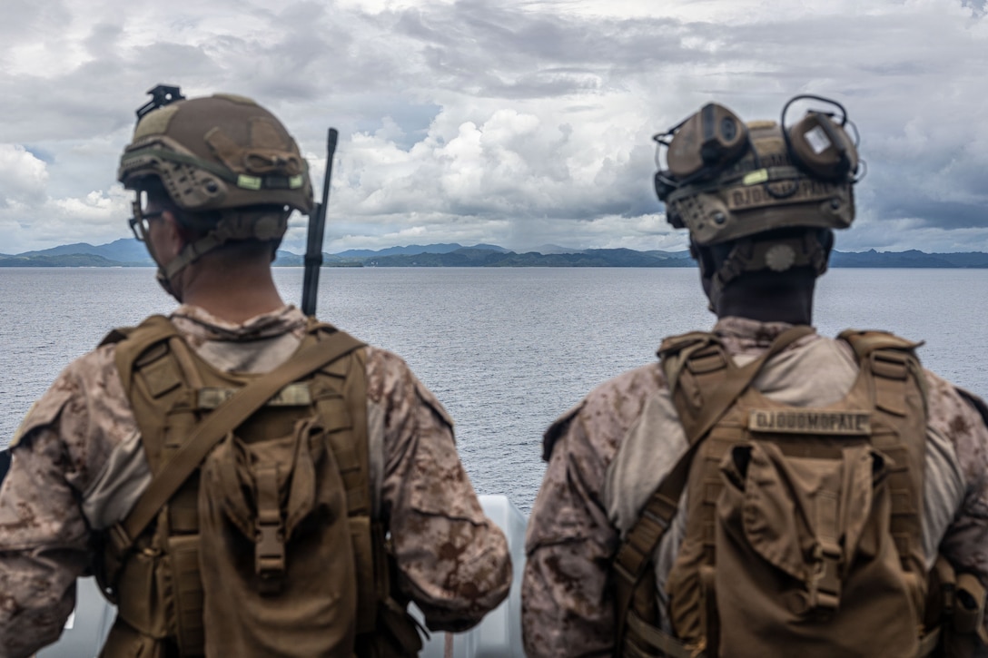 U.S. Marine Corps Cpl. Noah Olmeda, left, a low altitude aerial defense gunner with Marine Medium Tiltrotor Squadron (VMM) 163 (Reinforced), 11th Marine Expeditionary Unit, and Cpl. Charden Djouomopate, a cannoneer with Echo Battery, Battalion Landing Team 3/5, 11th MEU, scan for vessels aboard San Antonio-class amphibious transport dock ship USS Portland (LPD 27) while transiting the Surigao Strait, May 2, 2026.