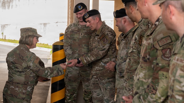 U.S. Air Force Chief Master Sgt. Katie McCool, left, Pacific Air Forces command chief, presents a coin to Staff Sgt. Daniel Karcher, 51st Security Forces Squadron Electronic Warfare Operations noncommissioned officer in charge, at Osan Air Base, Republic of Korea, April 23, 2026. Coining recognizes Airmen for their outstanding job performance, problem-solving capabilities, and leadership display. (U.S. Air Force photo by Senior Airman Jessica Mun)
