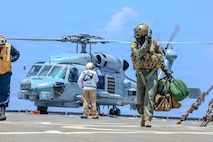 Royal Australian Navy Petty Officer Liam Sulley disembarks an MH-60R Seahawk, assigned to RAN Anzac-class frigate HMAS Toowoomba (FFH 156), on the flight deck of U.S. Navy Whidbey Island-class dock landing ship USS Ashland (LSD 48) during Exercise Balikatan 2026 in the South China Sea, April 26, 2026. Balikatan is a longstanding annual exercise between the Armed Forces of the Philippines and U.S. military that represents the strength of our alliance, improves our capable combined force, and demonstrates our commitment to regional peace and prosperity. (U.S. Navy photo by Mass Communication Specialist Seaman Maliq J. Martin)