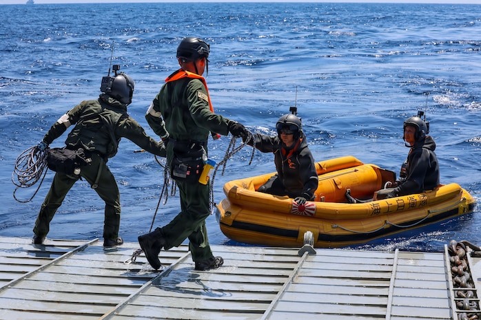 Crewmembers of a Japan Maritime Self-Defense Force ShinMaywa US-2 aircraft, assigned to Air Rescue Squadron 71 (ARS-71), Fleet Air Wing 31, secure their small boat to the stern gate of U.S. Navy Whidbey Island-class dock landing ship USS Ashland (LSD 48) during a casualty evacuation exercise for Exercise Balikatan 2026 in the South China Sea, April 27, 2026. Balikatan is a longstanding annual exercise between the Armed Forces of the Philippines and U.S. military that represents the strength of our alliance, improves our capable combined force, and demonstrates our commitment to regional peace and prosperity. (U.S. Navy photo by Mass Communication Specialist 1st Class John B. Hetherington)