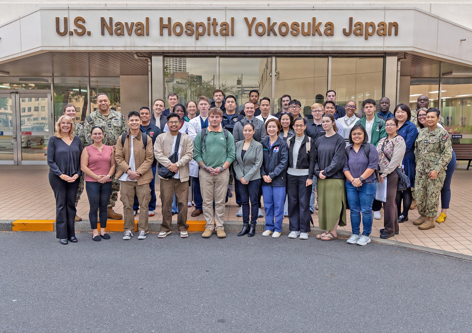 YOKOSUKA, Japan (April 15, 2026) — Capt. Torrin W. Velazquez, director of U.S. Naval Hospital (USNH) Yokosuka, poses for a group photo with instructors, organizers and participants of the High-Level Disinfection and Sterilization (HLD/SPD) workshop outside USNH Yokosuka, April 15. Hosted for the first time in mainland Japan, the workshop brought together nearly 100 participants from across the Indo-Pacific and beyond to strengthen standardized sterilization and high-level disinfection practices supporting patient safety, mission success and force health protection. (U.S. Navy photo by Daniel Taylor/USNMRTC Yokosuka Public Affairs)