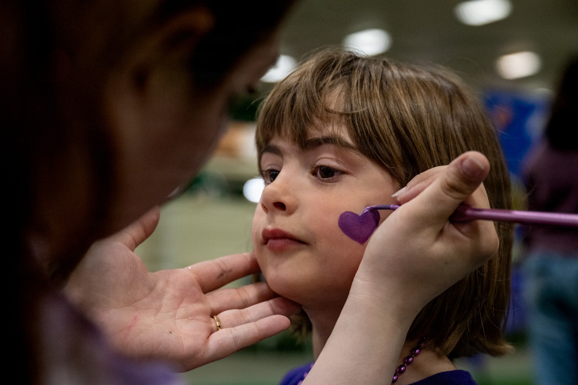 A Purple Palooza volunteer paints the face of a participant at Misawa Air Base, Japan, April 30, 2026.