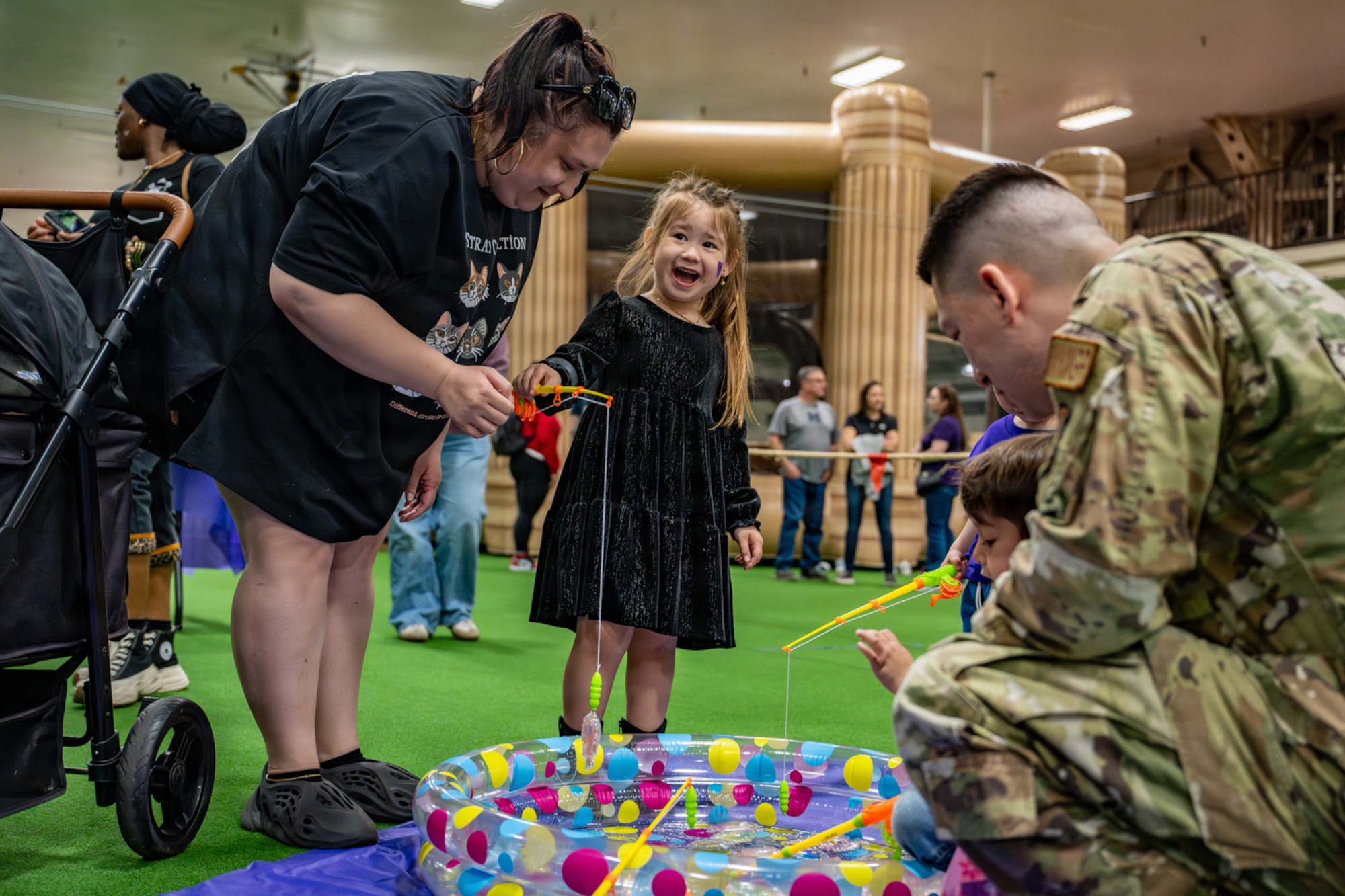 Purple Palooza participants play a magnetic fishing game in a small pool at Misawa Air Base, Japan, April 30, 2026.