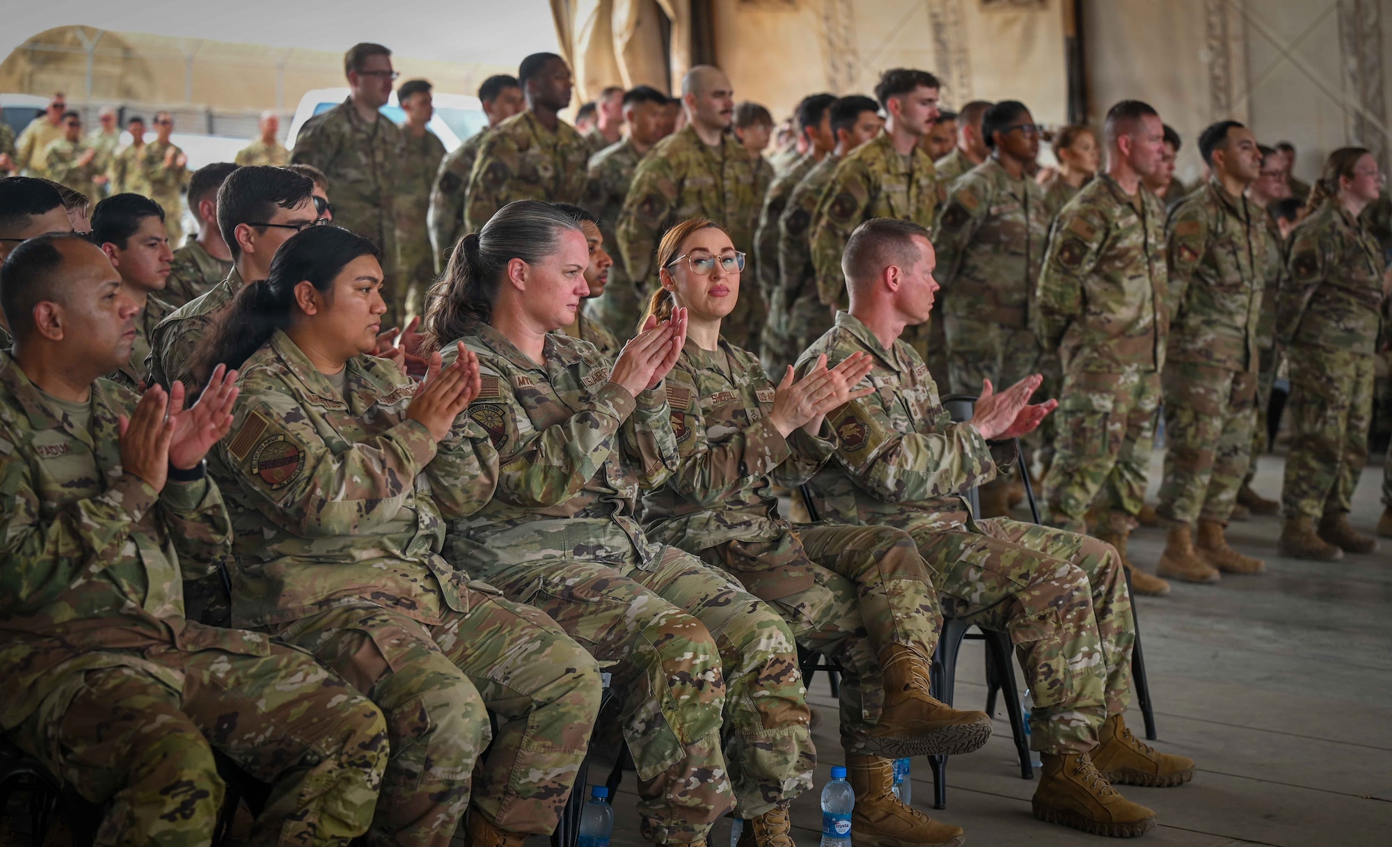 U.S. Airmen clap while attending a change of command ceremony at Chabelley Airfield, Djibouti, April 24, 2026. The change of command ceremony is a military tradition that represents a formal transfer of authority and responsibility for a unit. (U.S. Army photo by SGT Vivian Nakaana)