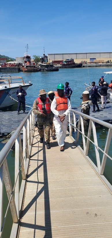 A suspected drug smuggler is escorted up the gangway following a drug interdiction off Haiti, May 3, 2026. At the behest of the Haitian government, a U.S. Coast Guard law enforcement detachment deployed on the USS Billings stopped a suspected drug vessel carrying approximately 3,200 pounds of marijuana. (U.S. Coast Guard photo)