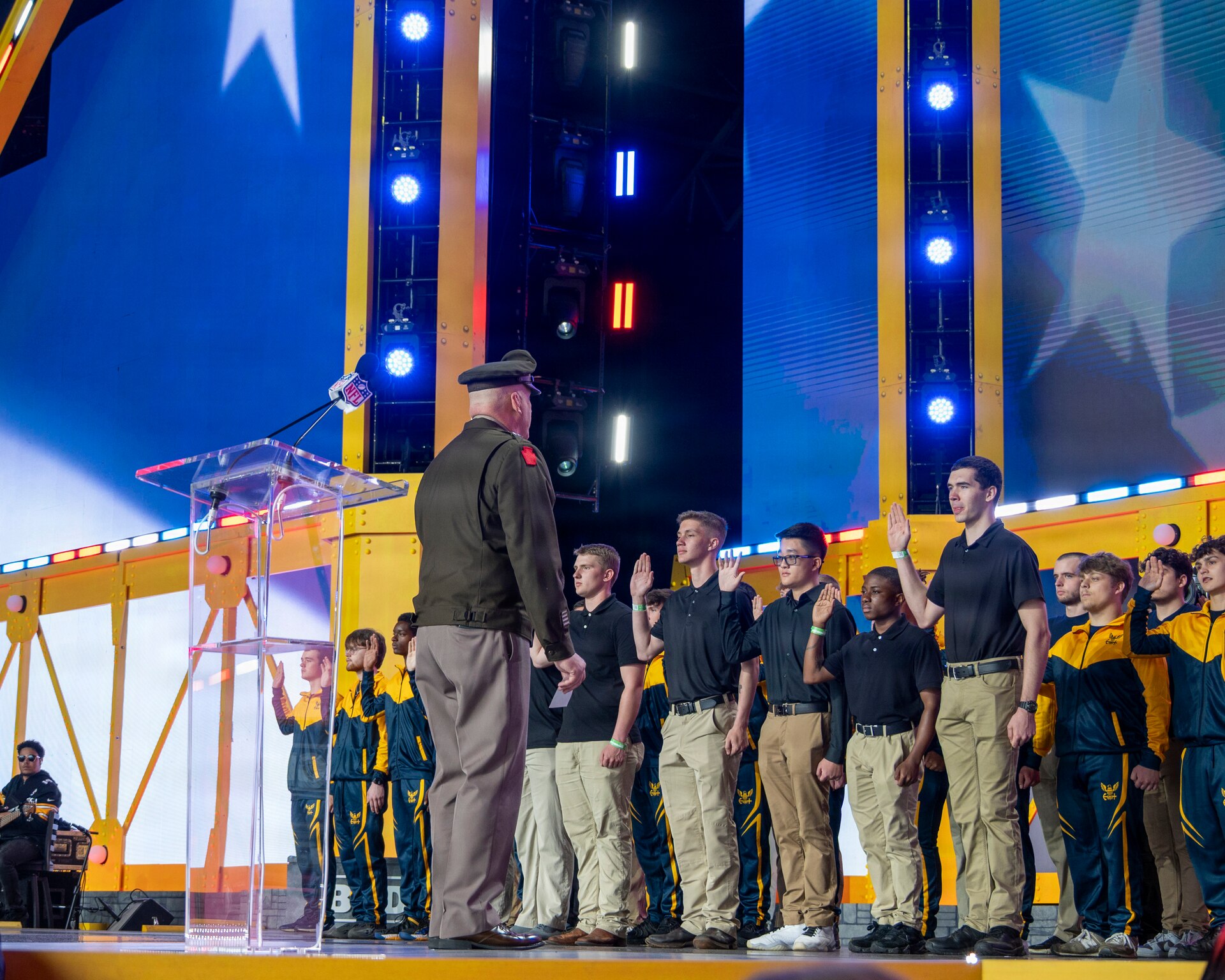 Future Soldiers and Airmen stand on stage during a multi-service enlistment ceremony at the NFL Draft at Acrisure Stadium, April 25, 2026. Approximately 180 individuals took the oath of enlistment, marking the start of their service to the commonwealth and the nation. (U.S. Air National Guard photo by Tech. Sgt. Zoe M. Wockenfuss)