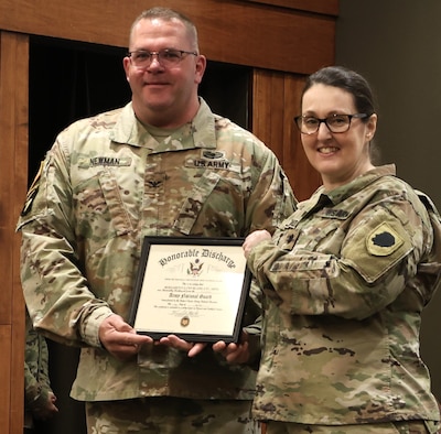 Lt. Col. Bernadette Bland of Belvidere, a veteran of two overseas deployments and multiple domestic emergency missions, holds her Honorable Discharge from the U.S. Army with Col. Timothy Newman during her ceremony at the Illinois Military Academy Auditorium on Camp Lincoln in Springfield, Ill on May 3, 2026