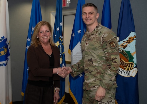 image of woman shaking Airman's hand.