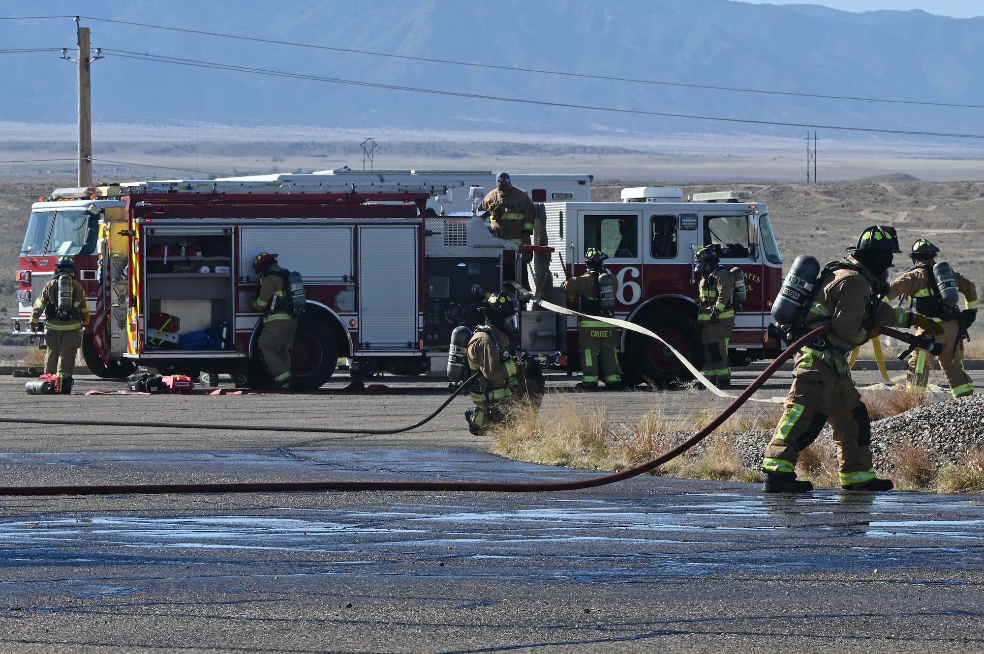 Team Kirtland fire protection specialists respond to a simulated aircraft burn pit as part of a Kirtland Air Force Base Fire and Emergency Services (KFES) exercise.