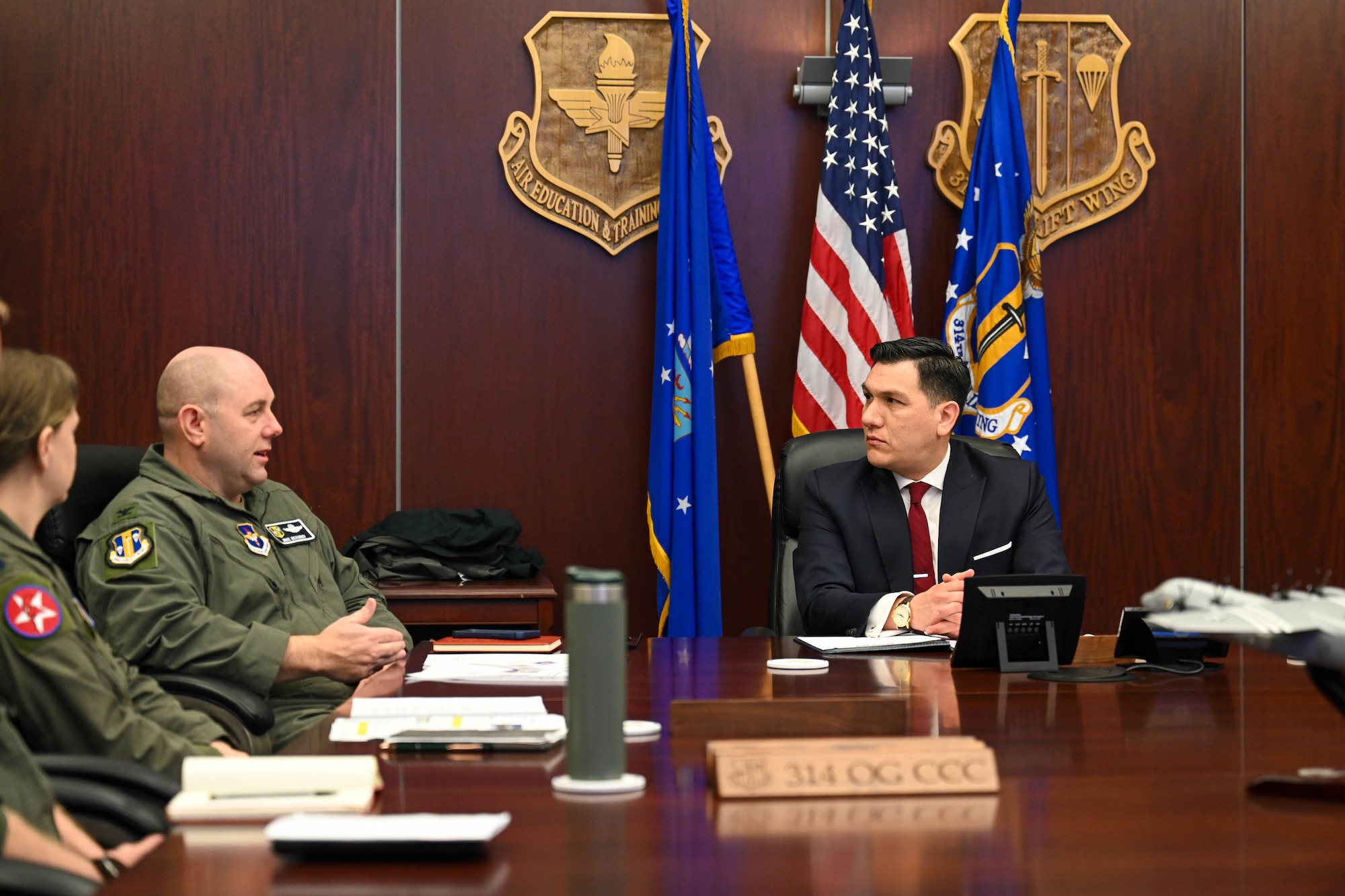 Two men sit at a table and talk.