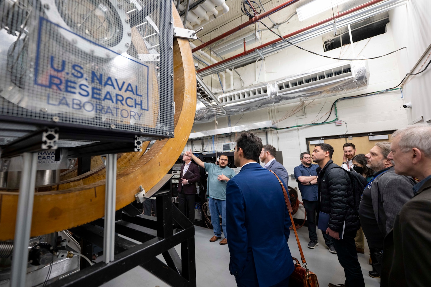 Erik Tejero (second from left), Ph.D., U.S. Naval Research Laboratory (NRL) research physicist, conducts a tour of the Space Chamber during NRL’s Innovation Day for Industry in Washington, D.C., April 28, 2026. The event focused on informing industry and assessing interest in a focused set of emerging technologies that are ready for collaboration with industry partners. (U.S. Navy photo by Sarah Peterson)