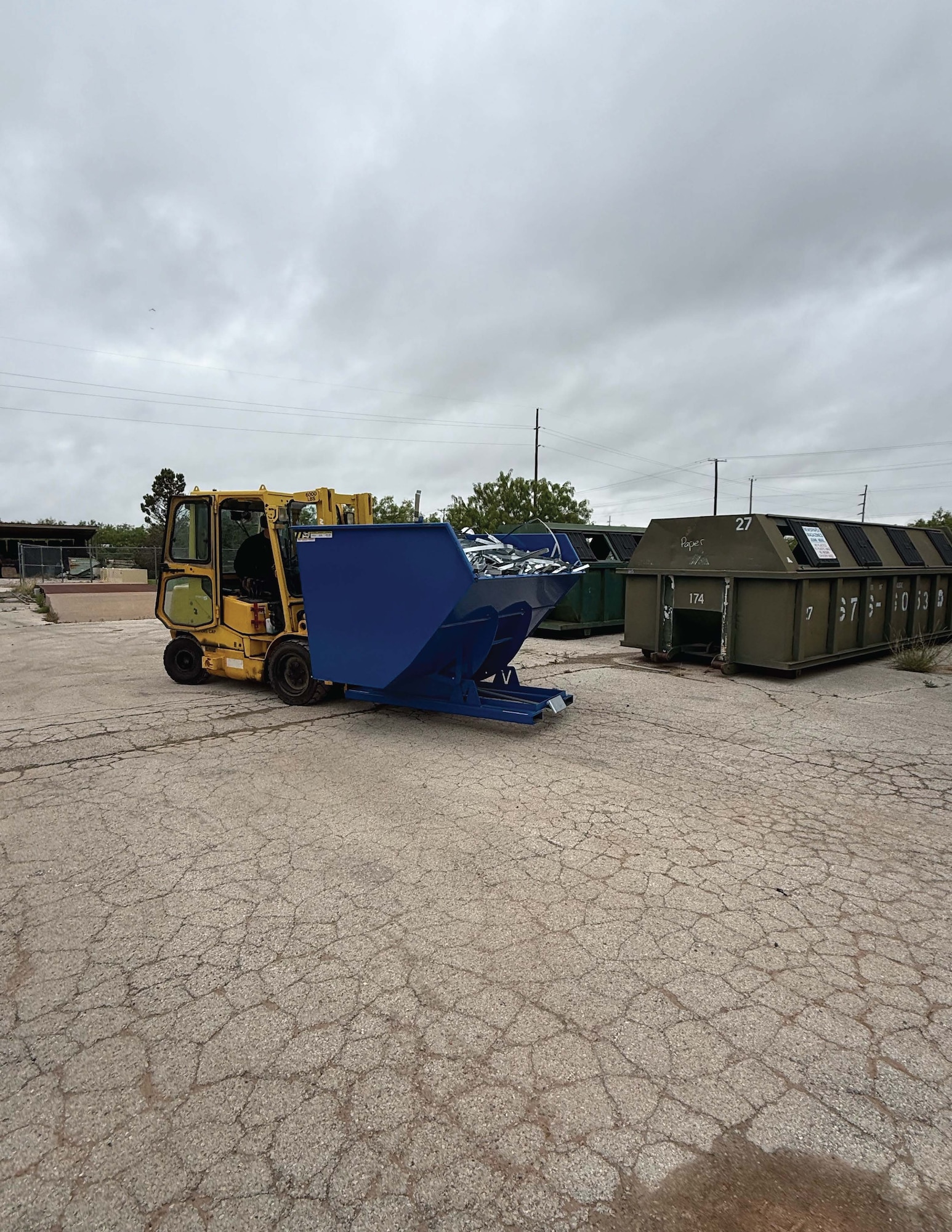 a forklift moves a dumpster