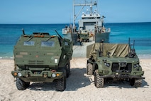 A U.S. Marine Corps Navy-Marine Expeditionary Ship Interdiction System, right, assigned 3rd Littoral Combat Team, 3rd Marine Littoral Regiment, 3rd Marine Division, and a U.S. Army M142 High Mobility Artillery Rocket System assigned to 7th Infantry Division, Multi-Domain Command - Pacific, are staged on the beach after a joint ship-to-shore movement during Exercise Balikatan 2026 in Calayan, Cagayan, Philippines, April 28, 2026.