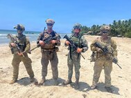 From left, Pvt. Alex Risely, 5th/7th Battalion, The Royal Australian Regiment, 2nd Lt. Nicholas Licalzi, U.S. Marine Corps Rotational Force – Darwin, 1st Lt. Miguel Orozco, Philippine 3rd Marine Brigade, and Pvt. Peni Vakafa, 2nd/1st Battalion, Royal New Zealand Infantry Regiment, stand shoulder to shoulder in front of autonomous maritime targets after a counter-landing live-fire exercise during Balikatan 2026, at Aporawan, Philippines, April 27, 2026.