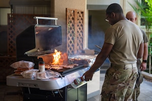 A man grills meat on a grill.
