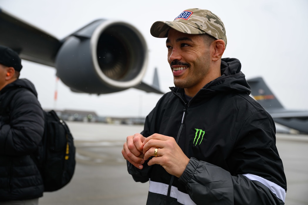 A person dons hearing protection before boarding a cargo aircraft for a tour.