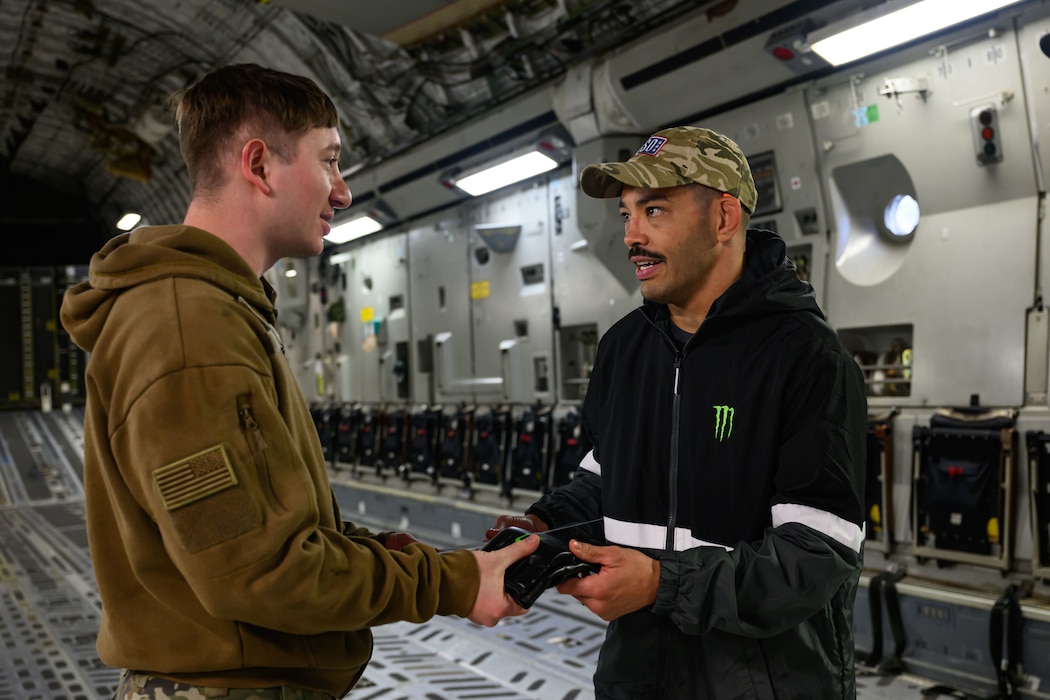 Two people greet each other inside a cargo aircraft.