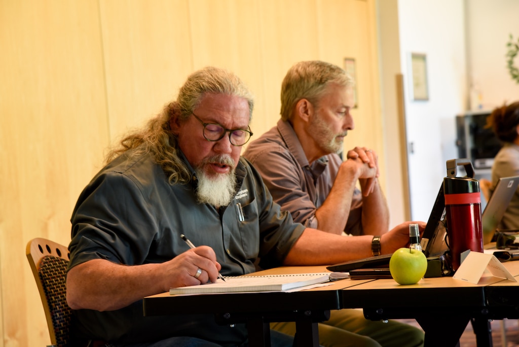 a man sitting at a table taking notes