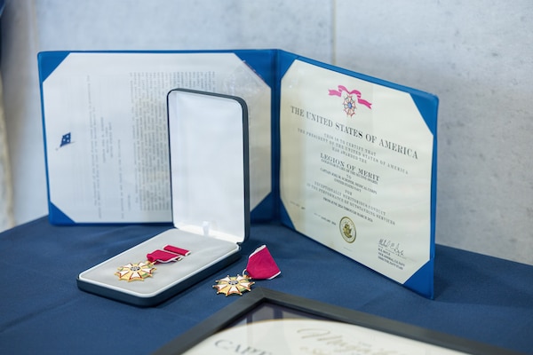 AGANA HEIGHTS (March 27, 2026) – A Legion of Merit award and medal sit on a table during the change of command ceremony for U.S. Navy Medicine Readiness and Training Command (USNMRTC) Guam Commanding Officer Capt. Joel M. Schofer, March 27. The ceremony marked the transition of leadership from Schofer to Capt. James G. Demitrack who also became the director of U.S. Naval Hospital (USNH) Guam. The award was presented to Schofer in recognition of his accomplishments while at the helm of USNMRTC and USNH Guam and served as a fitting culmination of his distinguished 29 years of dedicated military service.