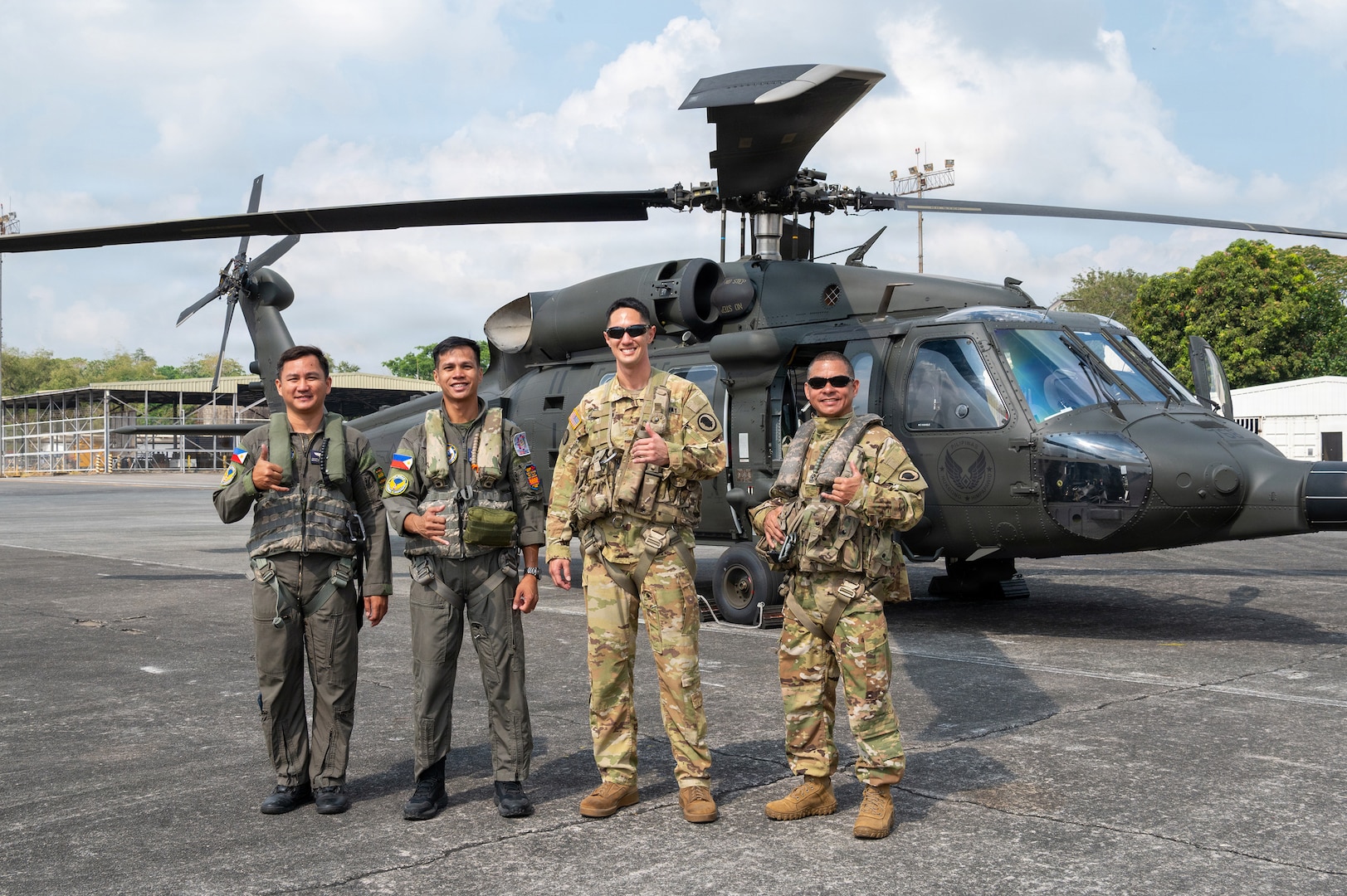 Philippine Air Force Sgt. Julius Chun Manasan, left, mechanic assigned to the 205th Tactical Helicopter Wing; U.S. Army 1st Sgt. Christopher Pacheco, center left, senior mechanic and standardization instructor assigned to the Hawaii Army National Guard; Philippine Air Force Lt. Col. John Paul Delgado, center, commander of the 210th Tactical Training Squadron; and U.S. Army Maj. John Worthington, right, Army Aviation Support Facility commander, standardization pilot and instrument examiner assigned to the Hawaii Army National Guard, pose for a photo in front of a Philippine Air Force S-70i Black Hawk helicopter during a Rotary Wing Subject Matter Expert Exchange Clark Air Base, Philippines, April 15, 2026.